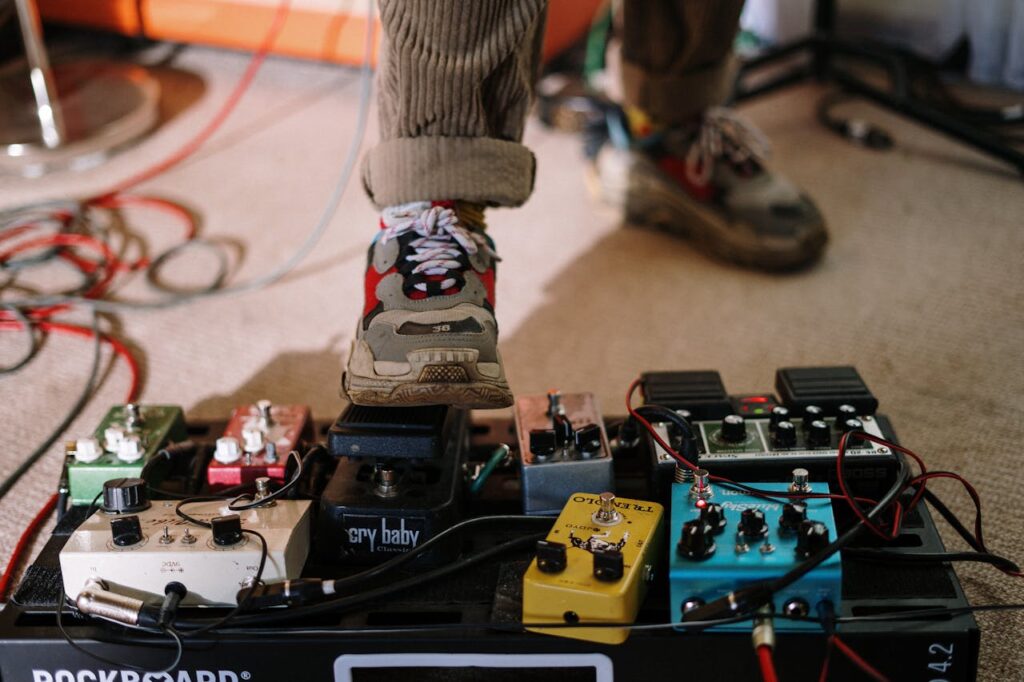 Close-up of a musician's foot on a guitar pedal board in a home music studio.